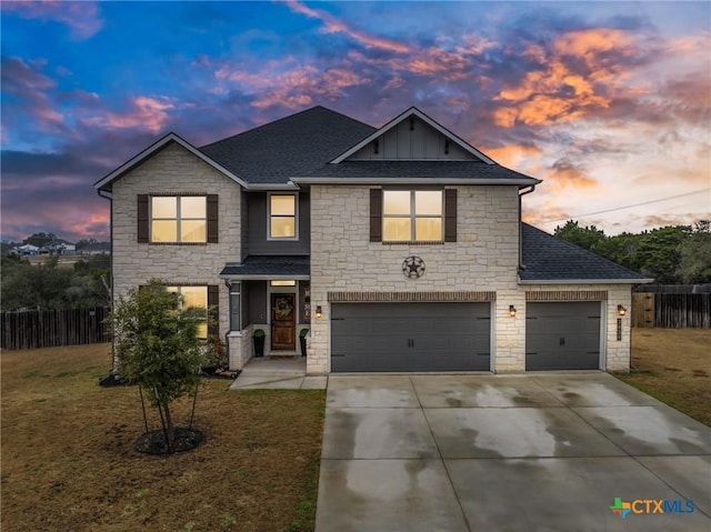 traditional home featuring driveway, a shingled roof, a lawn, fence, and board and batten siding