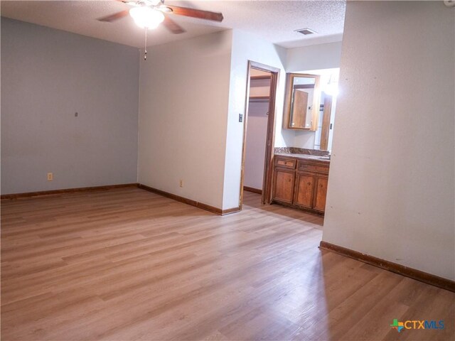 unfurnished room with baseboards, ceiling fan, visible vents, and light wood-style flooring