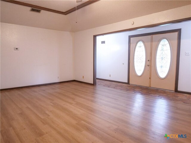 foyer entrance with baseboards, light wood-type flooring, and visible vents