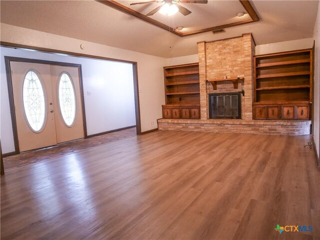 unfurnished living room with a textured ceiling, baseboards, a ceiling fan, and wood finished floors