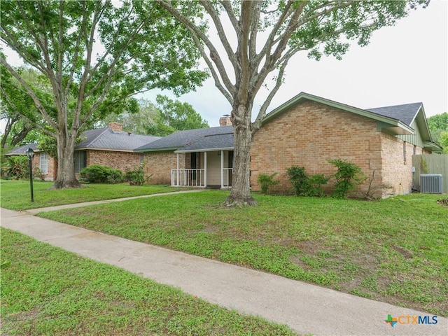 ranch-style house with central AC unit, a front lawn, and brick siding