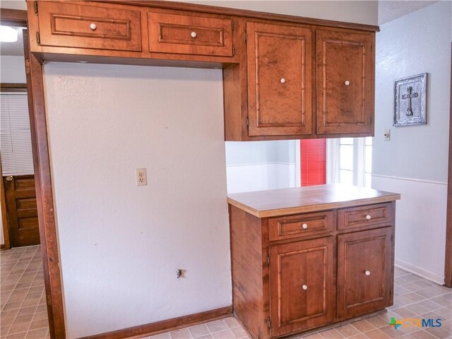 kitchen with light countertops, baseboards, and brown cabinets