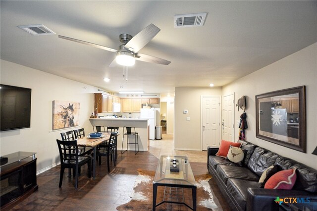 living room with ceiling fan and dark hardwood / wood-style flooring