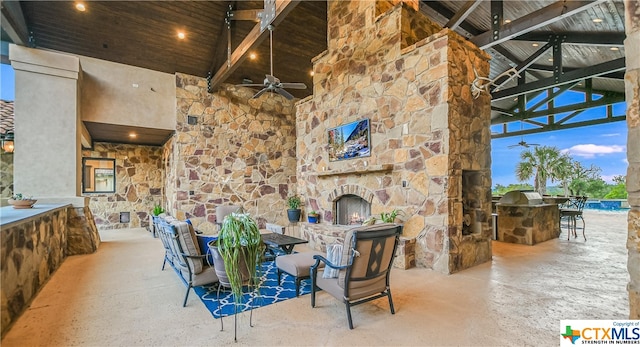 view of patio / terrace featuring an outdoor kitchen, ceiling fan, an outdoor bar, and an outdoor stone fireplace