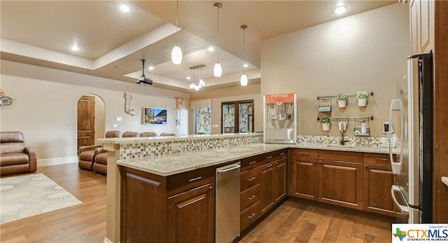 kitchen with stainless steel fridge, kitchen peninsula, and a tray ceiling