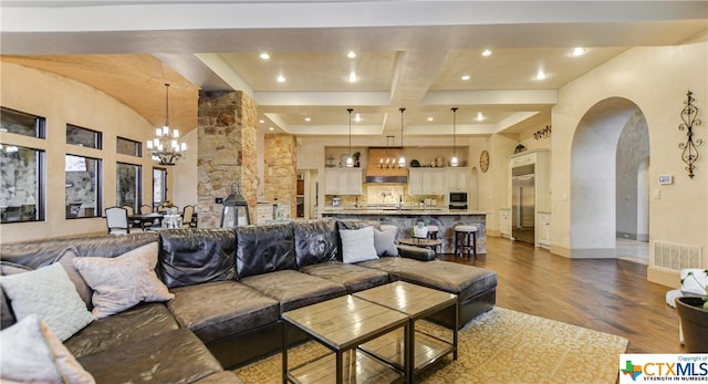 living room with dark hardwood / wood-style floors, beam ceiling, coffered ceiling, a towering ceiling, and a notable chandelier