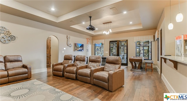 home theater with hardwood / wood-style flooring and a raised ceiling