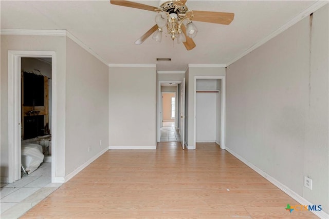 unfurnished room featuring crown molding, light wood finished floors, visible vents, a ceiling fan, and baseboards