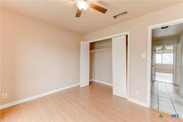 unfurnished bedroom with light wood finished floors, ceiling fan, baseboards, and a closet