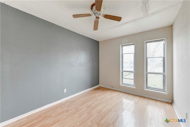 unfurnished room featuring light wood-style floors, ceiling fan, and baseboards