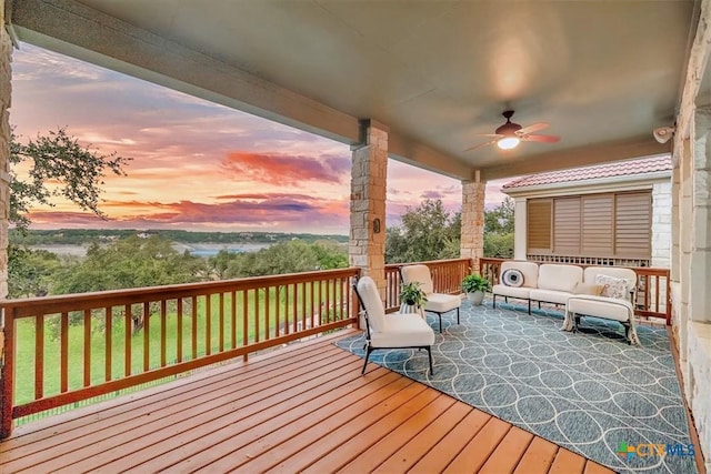 deck at dusk with an outdoor hangout area and ceiling fan