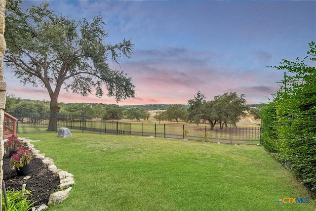 yard at dusk featuring a rural view