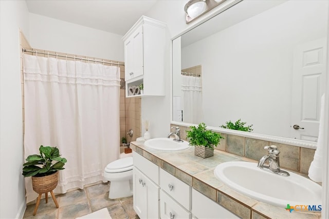 full bathroom with vanity, shower / bath combo with shower curtain, and toilet