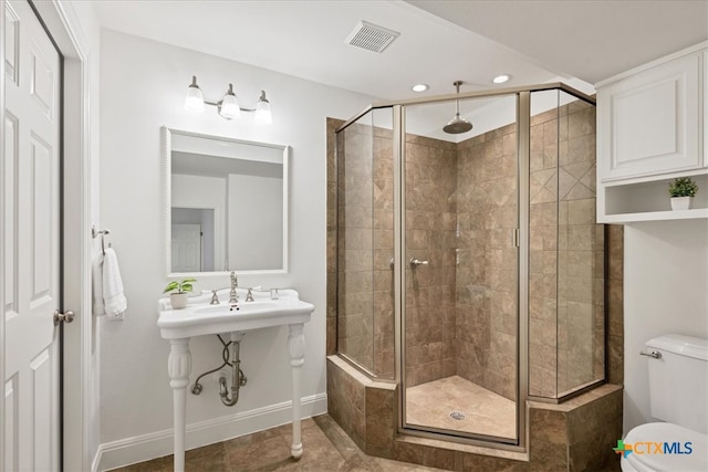 bathroom with walk in shower, toilet, and tile patterned flooring