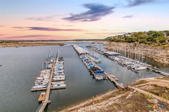 aerial view at dusk featuring a water view