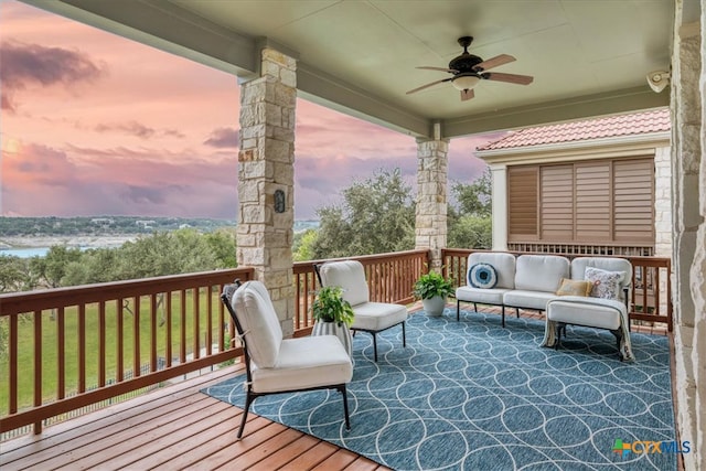 deck at dusk featuring ceiling fan and outdoor lounge area