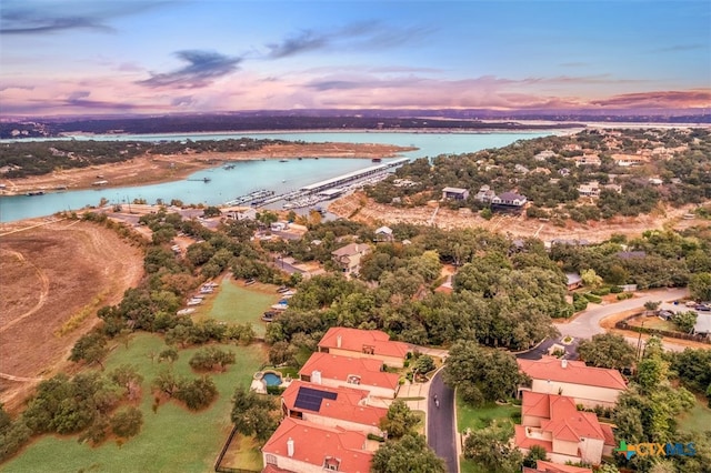 aerial view at dusk featuring a water view