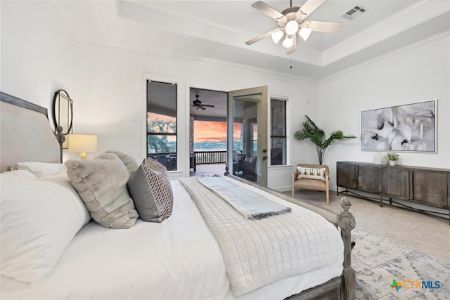 bedroom with crown molding, ceiling fan, a tray ceiling, carpet floors, and access to outside