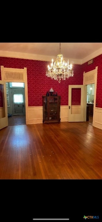 unfurnished dining area featuring dark hardwood / wood-style floors and a chandelier