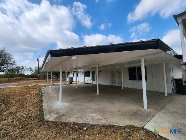 view of patio with an attached carport, french doors, and central AC unit