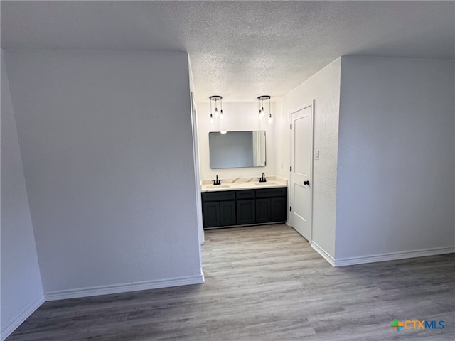 bathroom with wood-type flooring, vanity, and a textured ceiling