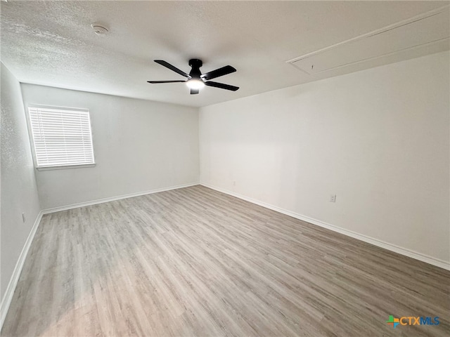 spare room featuring a textured ceiling, ceiling fan, and light hardwood / wood-style flooring