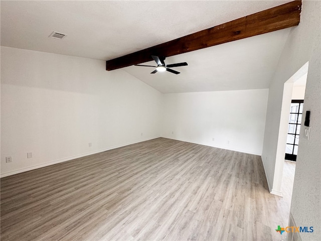 empty room featuring ceiling fan, vaulted ceiling with beams, and light hardwood / wood-style flooring