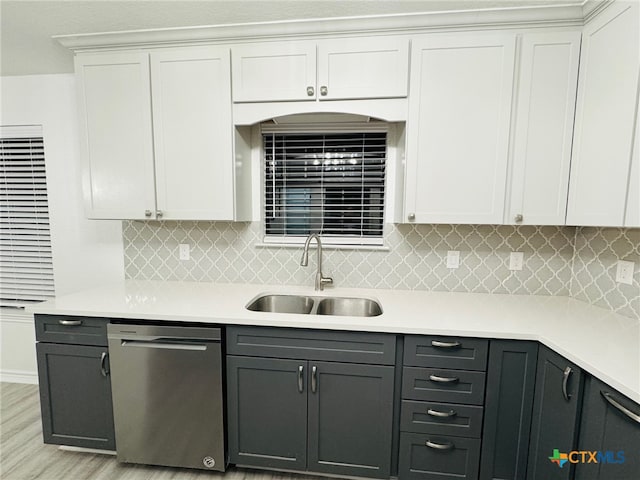 kitchen featuring light hardwood / wood-style floors, dishwasher, white cabinets, sink, and backsplash