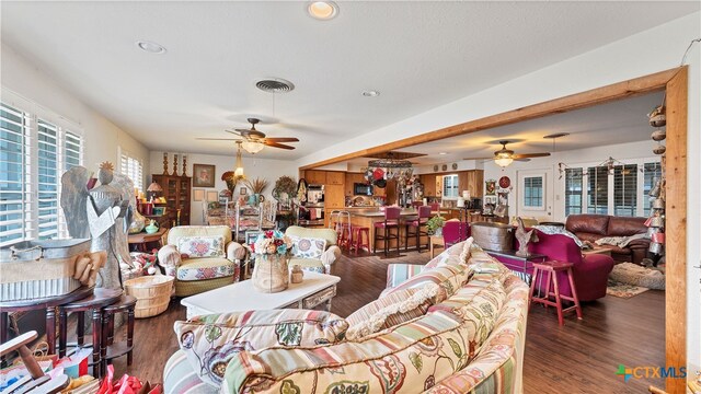 living room featuring dark wood-type flooring and ceiling fan