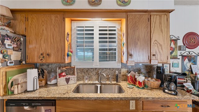 kitchen featuring stainless steel dishwasher, light stone countertops, sink, and backsplash