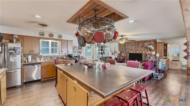 kitchen featuring ceiling fan, dark hardwood / wood-style floors, pendant lighting, and appliances with stainless steel finishes