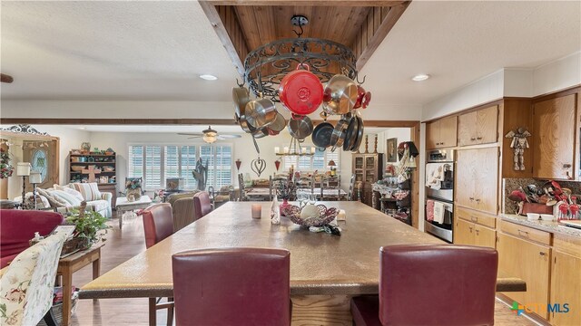 dining space featuring light hardwood / wood-style flooring and ceiling fan with notable chandelier