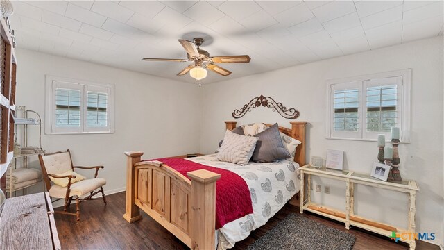 bedroom featuring multiple windows, ceiling fan, and dark hardwood / wood-style floors