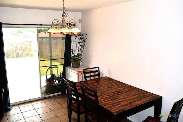 dining area featuring tile patterned floors and a chandelier