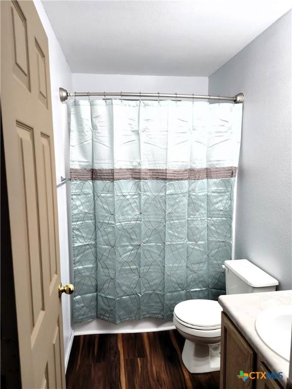 1402 Fox Creek Dr, Killeen, TX 76543 - full bathroom featuring toilet, a shower with curtain, wood finished floors, and vanity