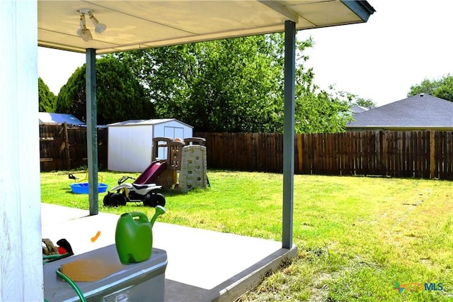 view of yard featuring a storage shed, a patio area, a fenced backyard, and an outdoor structure
