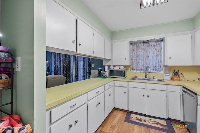 kitchen with white cabinetry, sink, stainless steel appliances, and light hardwood / wood-style floors