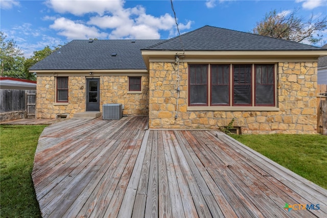 deck featuring central AC unit and a yard