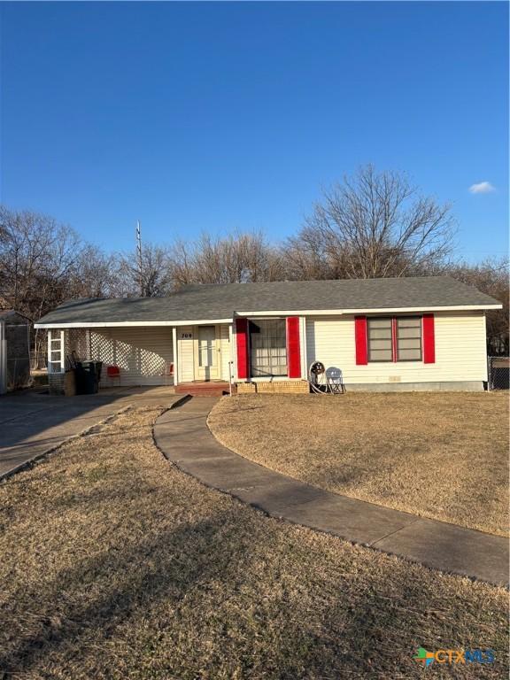 single story home with a front lawn and a carport