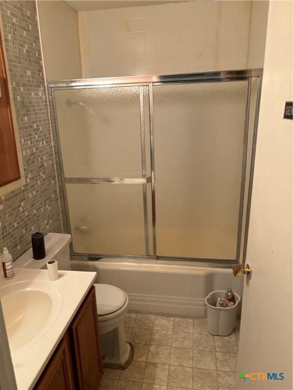 full bathroom with vanity, backsplash, tile walls, toilet, and combined bath / shower with glass door