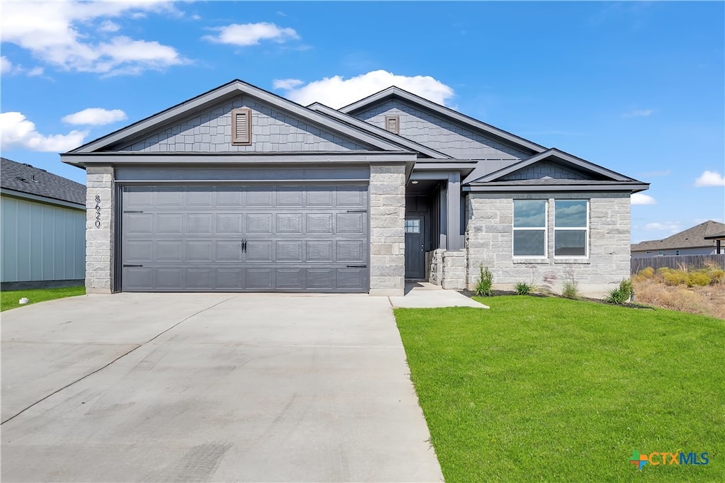 craftsman-style house featuring a front yard and a garage