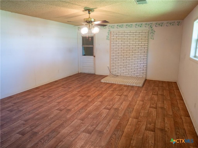 spare room featuring visible vents, a textured ceiling, a ceiling fan, and wood finished floors