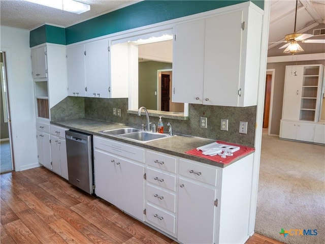 kitchen with tasteful backsplash, white cabinetry, a ceiling fan, stainless steel dishwasher, and a sink