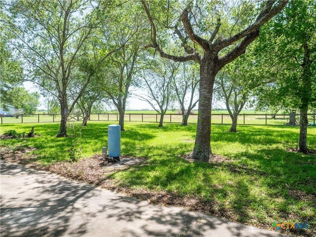 view of community with a yard and fence