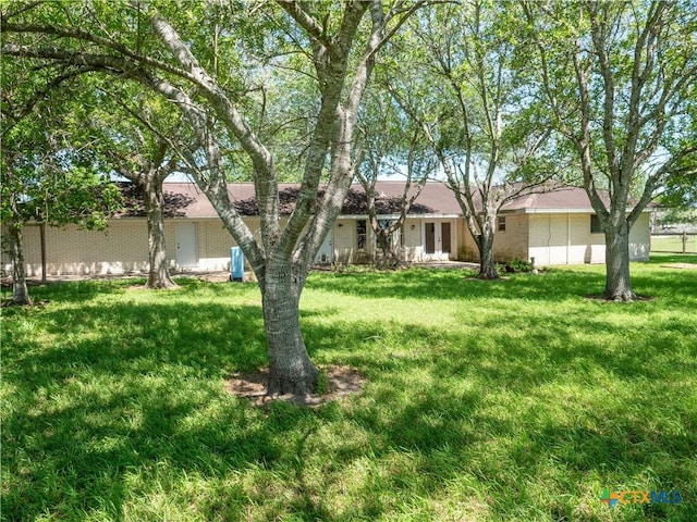 exterior space with french doors, a front yard, and brick siding