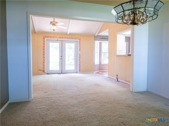 interior space featuring french doors, baseboards, ceiling fan with notable chandelier, and lofted ceiling with beams