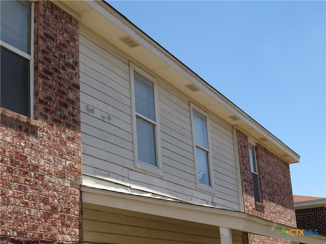 view of side of home with brick siding