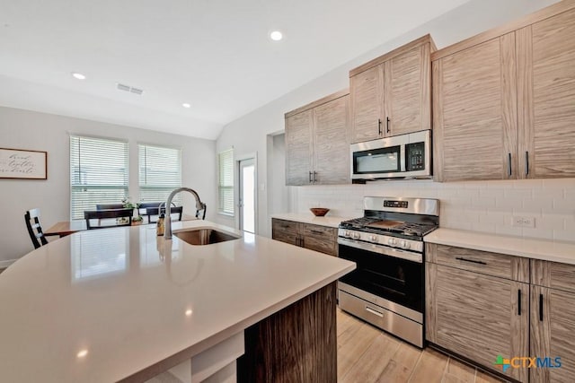 123 Paul Pena Dr, San Marcos, TX 78666 - kitchen with appliances with stainless steel finishes, a sink, light countertops, decorative backsplash, and recessed lighting
