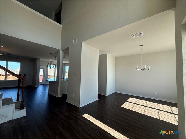 unfurnished living room with a wealth of natural light, ceiling fan, and dark hardwood / wood-style flooring