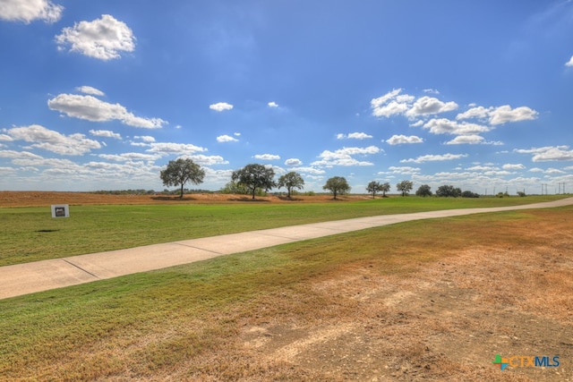 view of property's community with a rural view and a lawn